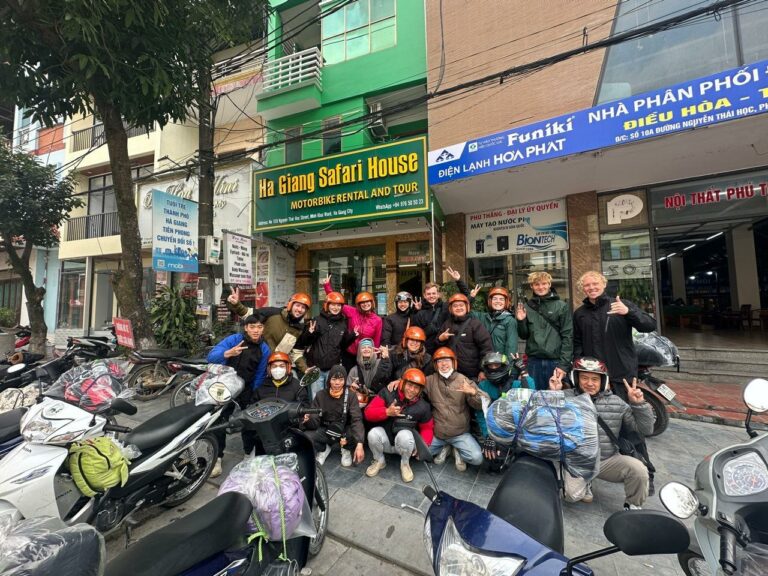 Group photo of travelers and easy drivers outside of Ha Giang Safari Hostel