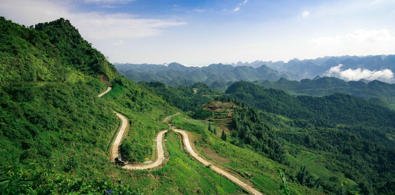 Windy road through lush green mountains in Northern Vietnam