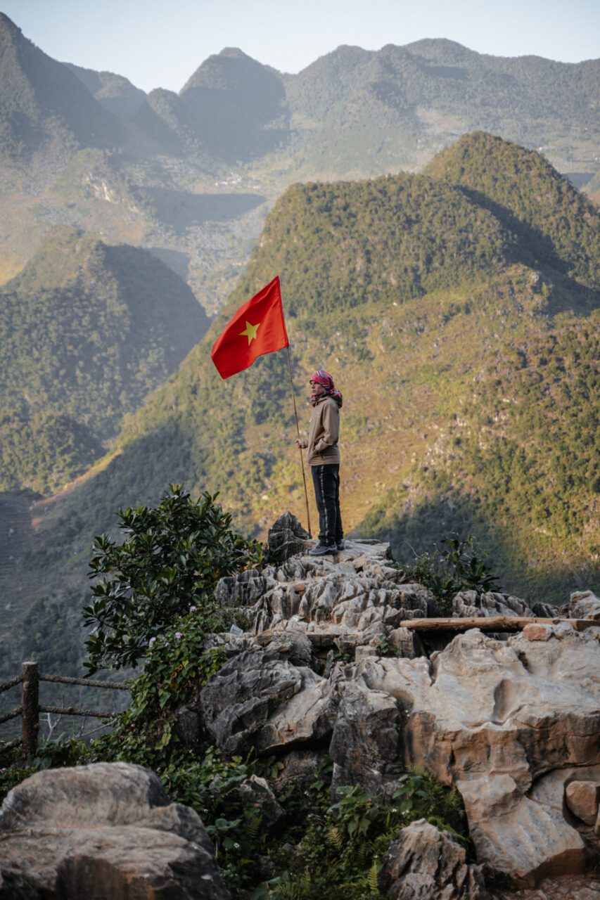 Traveler overlooking the green karst mountains of the Ha Giang Loop in Northern Vietnam
