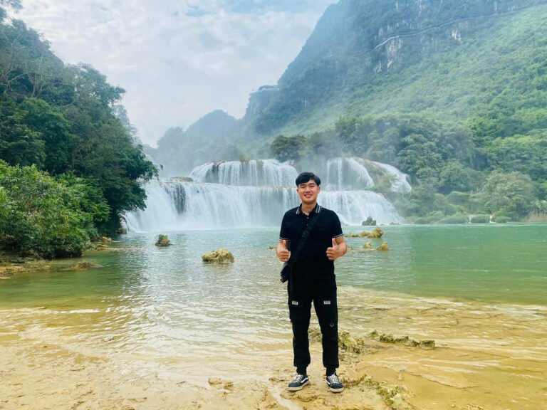 Guy smiling in front of waterfall